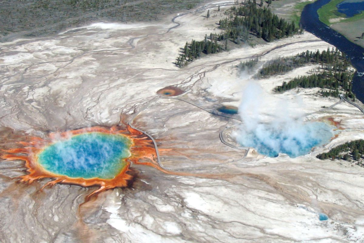 An aerial flight over Yellowstone’s Midway Geyser Basin in 2004 shows Grand Prismatic Spring and Excelsior Geyser Crater, which drain into the nearby Firehole River. 