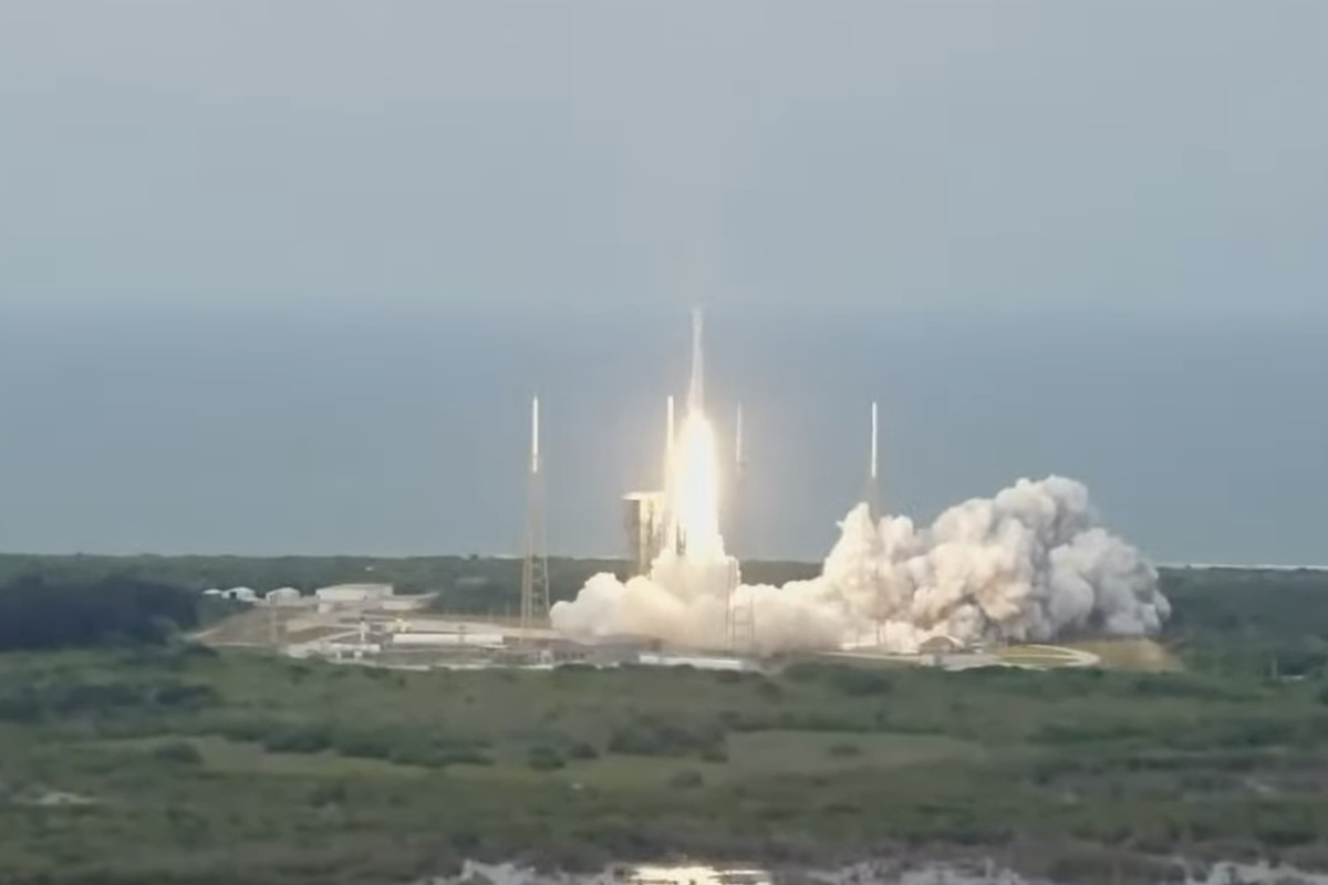 A rocket taking off on a cloudy day with a swamp in the foreground