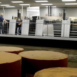 Operators load plates into the Heidelberg Speedmaster XL 106 printing press at KP Corporation in Salt Lake City on Wednesday, June 19, 2013.
