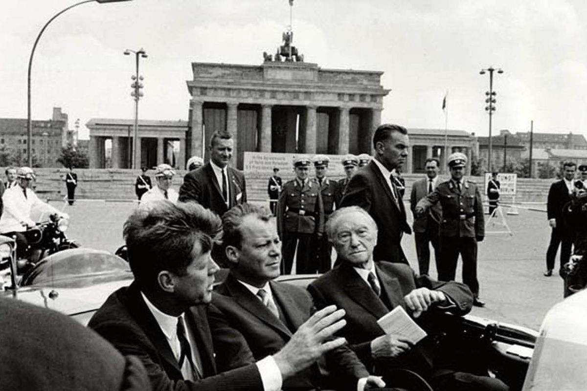 In this photo released by he Kennedy Museum, President John F. Kennedy, left, Willy Brandt, center, then mayor of West Berlin, and West German Chancellor Konrad Adenauer, right, ride in a car at the Brandenburg Gate on June 26, 1963. The day Kennedy visit