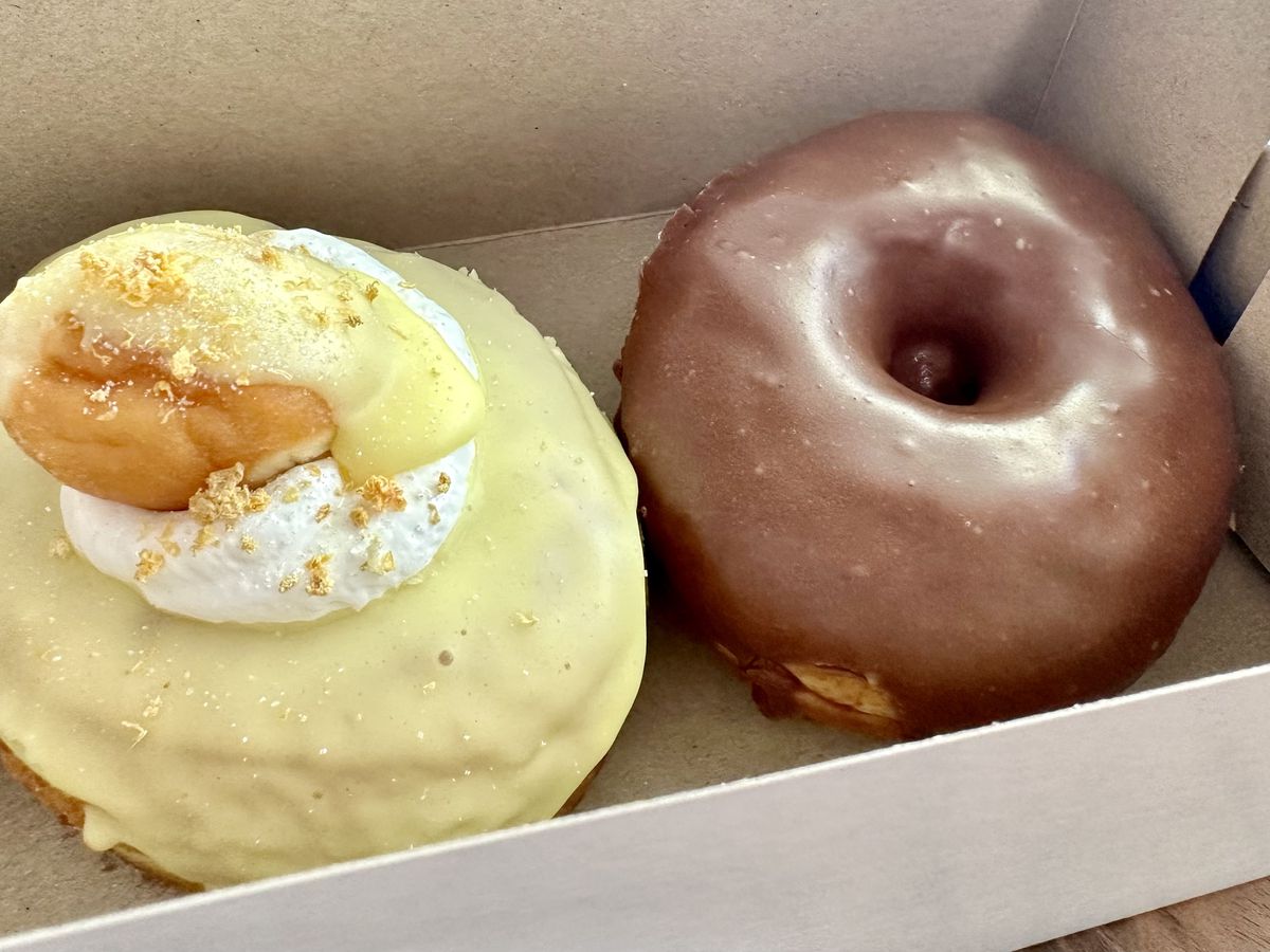 A donut with lemon glaze and meringue and a donut with chocolate glaze