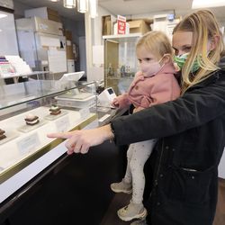 Catelin Goings holds daughter Margot Newman as they choose brownies at Brownies!  Brownies!  Brownies!  in Salt Lake City on Tuesday, December 22, 2020.