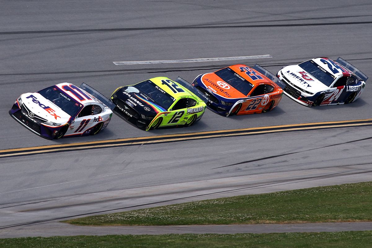 Denny Hamlin, driver of the #11 FedEx Ground Toyota, Ryan Blaney, driver of the #12 Menards/Sylvania Ford, Joey Logano, driver of the #22 Autotrader Ford, and William Byron, driver of the #24 Liberty University Chevrolet, race during the NASCAR Cup Series GEICO 500 at Talladega Superspeedway on April 25, 2021 in Talladega, Alabama.