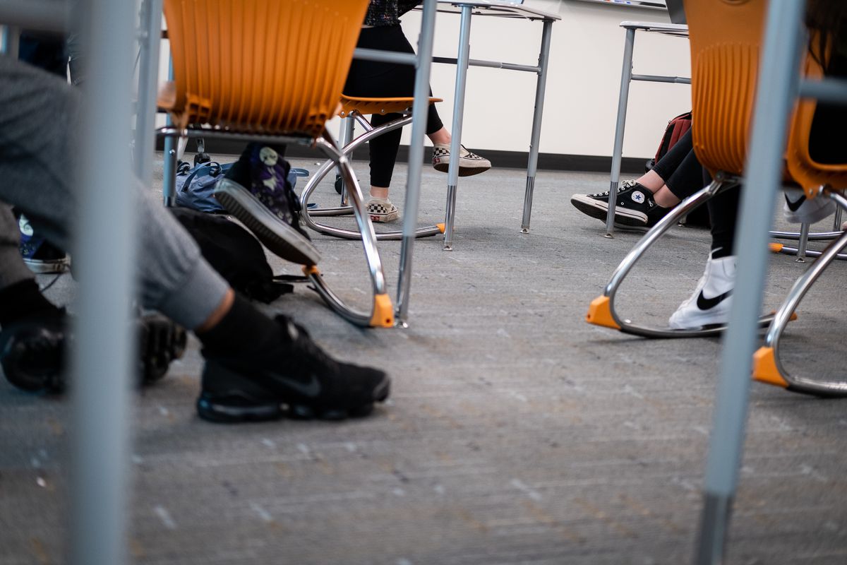 Students’ feet beneath their chairs in a classroom.