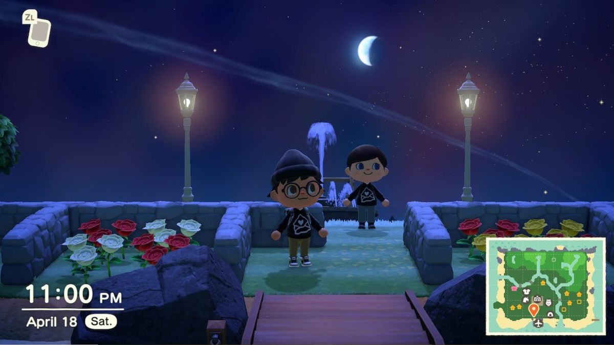 Two Animal Crossing residents stand on a moonlit section of the island, surrounded by stone fences, flowers, and street lamps.