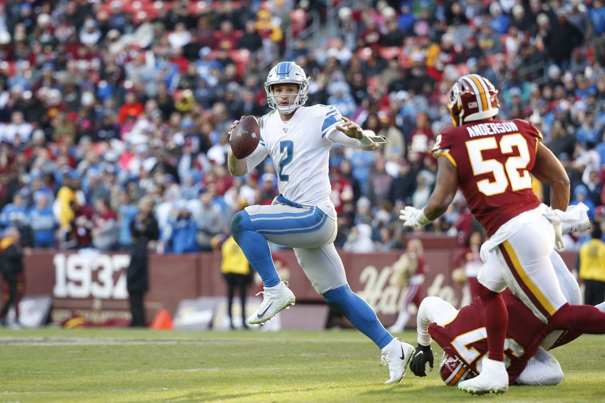 Detroit Lions quarterback Jeff Driskel scrambles with the ball past Washington defensive tackle Tim Settle and linebacker Ryan Anderson during the second half at FedExField.&nbsp;