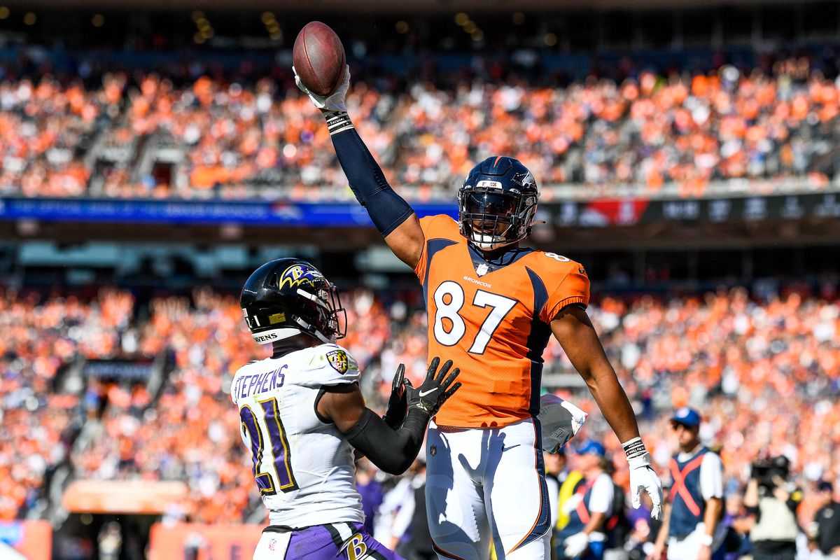 Noah Fant #87 of the Denver Broncos celebrates after a first quarter touchdown catch as Brandon Stephens #21 of the Baltimore Ravens covers the play at Empower Field at Mile High on October 3, 2021 in Denver, Colorado.&nbsp;