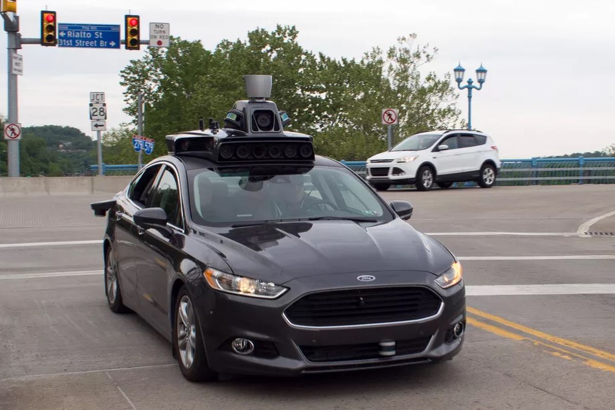 A parked, black self-driving car, with a sensor box on top.