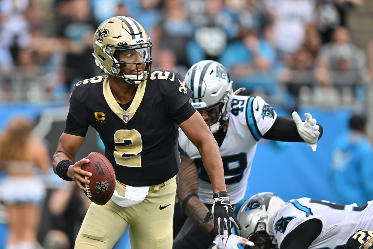 Jameis Winston #2 of the New Orleans Saints rolls out under pressure from Frankie Luvu #49 of the Carolina Panthers during their game at Bank of America Stadium on September 25, 2022 in Charlotte, North Carolina.
