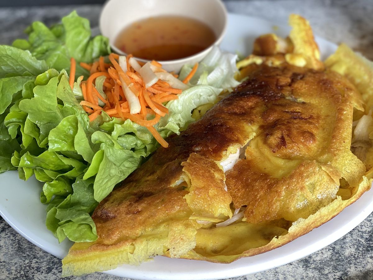 Bánh xèo served with salad and dipping sauce. 