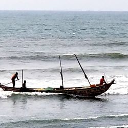 On a morning in Ghana, fishermen steer their boat back to shore.