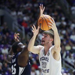 Weber State Wildcats center Alex Tew (20) drives on Brigham Young Cougars forward Fousseyni Traore (45) in Ogden on Saturday, Dec. 18, 2021. BYU won 89-71.