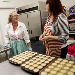 Leslie Fiet, left, owner of Mini's Gourmet Cupcakes, and Stephanie Deer talk in the kitchen of the cupcake shop in Salt Lake City on Friday, Feb. 6, 2015. Deer, a friend and artist, has been helping Fiet with the barrage of customers who have been coming into the shop since Fiet rescued a kidnapped 3-year-old girl on Wednesday evening.