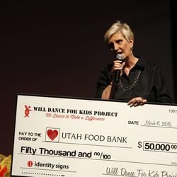 Ginette Bott of the Utah Food Bank accepts a $50,000 check in the Will Dance For Kids Project dance competition to raise money for the Utah Food Bank in Taylorsville on Saturday, March 7, 2015.