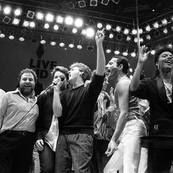 FILE - In this July 13, 1985, file photo, from left, George Michael of Wham!, concert promoter Harvey Goldsmith, Bono of U2, Paul McCartney, concert organizer Bob Geldof and Freddie Mercury of Queen join in the finale of the Live Aid famine relief concert, at Wembley Stadium, London. Michael, who rocketed to stardom with WHAM! and went on to enjoy a long and celebrated solo career lined with controversies, has died, his publicist said Sunday, Dec. 25, 2016. He was 53. 