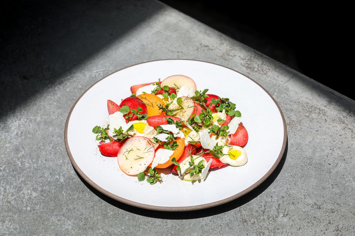A tomato salad on a white plate.