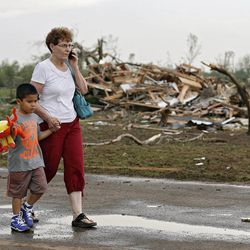 Chole Findley walks with her grandson Mark Williams as they leave the area where their home was destroyed  after the tornado hit the area near 149th and Drexel on Monday, May 20, 2013 in Oklahoma City, Okla.