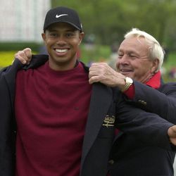 File-This March 18, 2001, file photo shows Tiger Woods, left, being helped into his jacket for winning the Bay Hill Invitational by tournament host Arnold Palmer  in Orlando, Fla. Woods Palmer, who made golf popular for the masses with his hard-charging style, incomparable charisma and a personal touch that made him known throughout the golf world as "The King," died Sunday, Sept. 25, 2016, in Pittsburgh. He was 87. 
