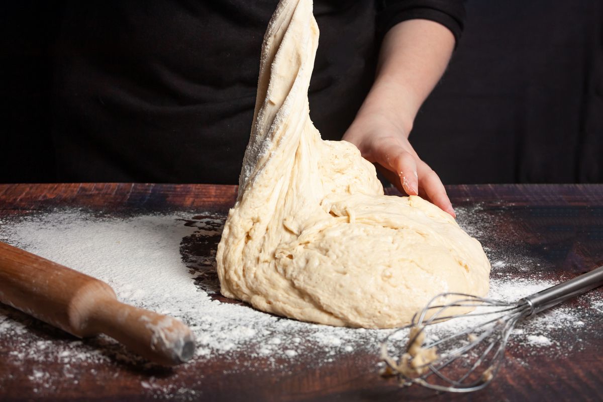 Hands kneading a heap of dough.