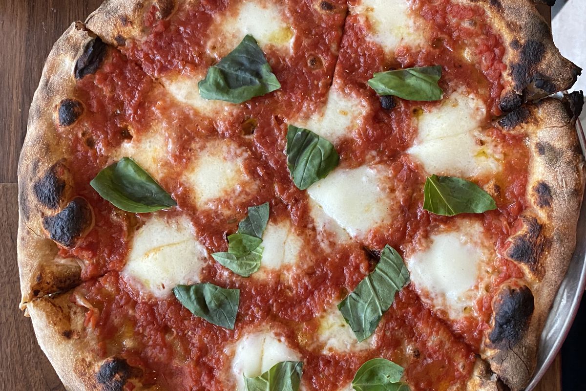 An overhead shot of the margherita pizza at Leo, showing off the pizza’s red tomatoes, green basil, and white mozzarella
