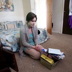 Skye Karlinsey, 19, looks at a memory box in her room, which includes photos of two friends who took their own lives, at her home in Ogden on Thursday, Feb. 22, 2018.