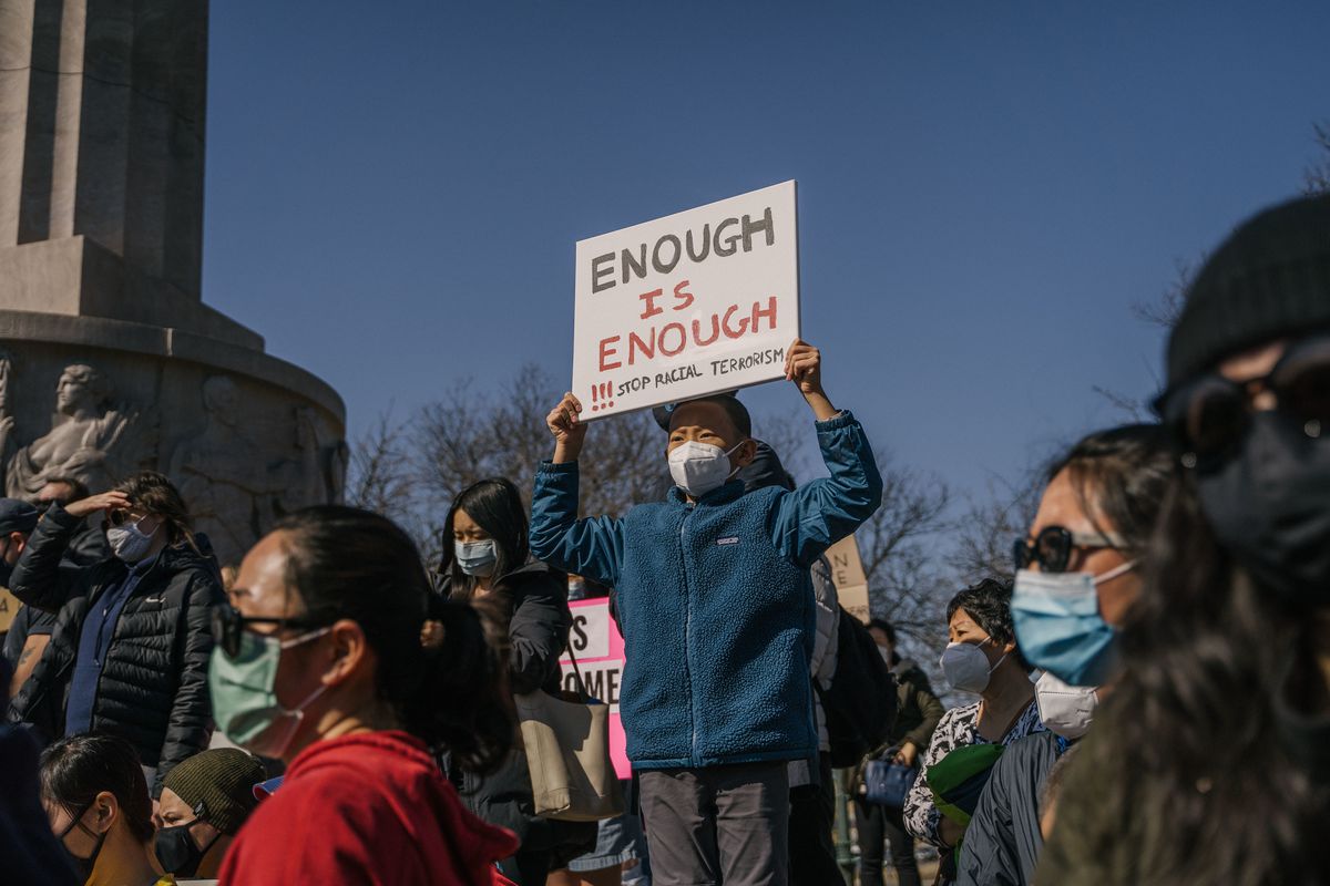 Vincent Gu, 10, holds a sign he made with his mother for the Stop Asian Hate March at the Illinois Centennial Monument in Logan Square, Saturday afternoon, March 20, 2021.
