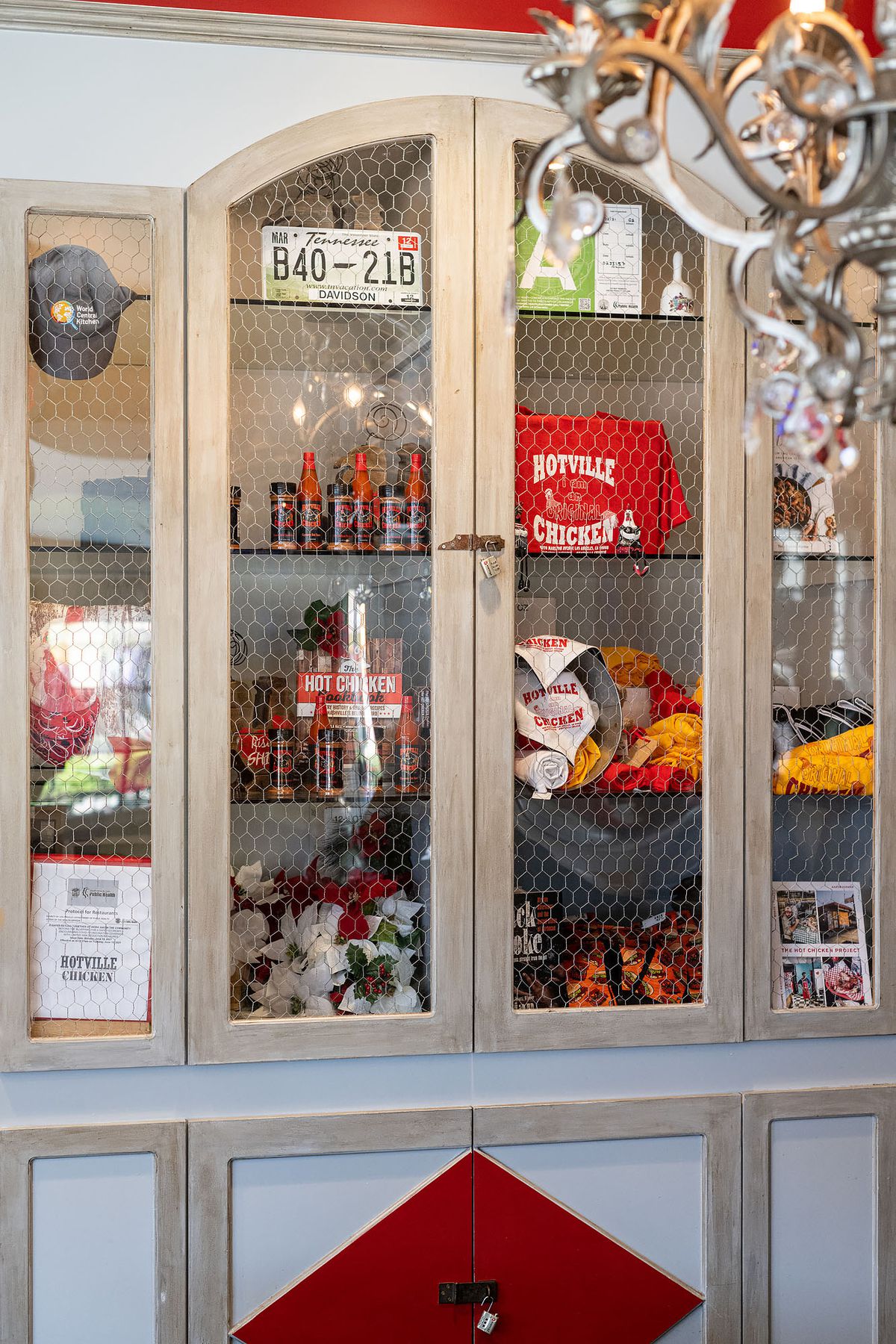 A glass display case holds Hotville merchandise like T-shirts, hot sauces, hats, and more.