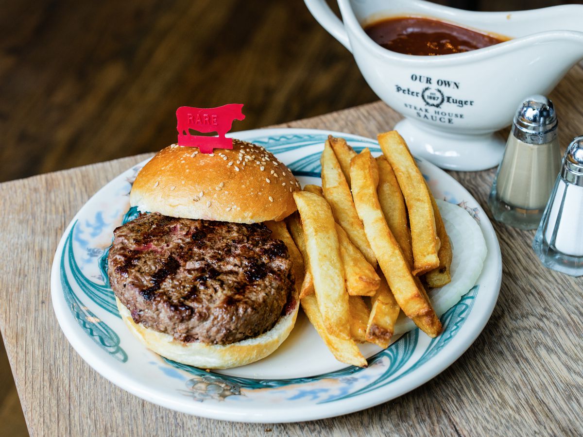 Peter Luger’s hamburger with fries, on a white plate with blue markings.
