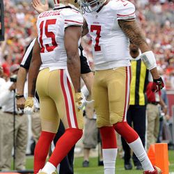 San Francisco 49ers quarterback Colin Kaepernick (7) celebrates with wide receiver Michael Crabtree (15) after Crabtree caught a 4-yard touchdown pass against the Tampa Bay Buccaneers during the first quarter of an NFL football game Sunday, Dec. 15, 2013, in Tampa, Fla. 