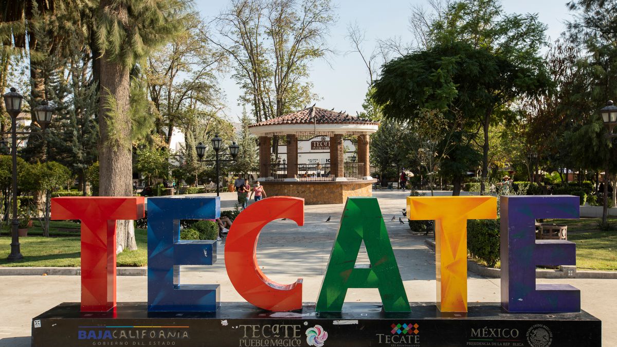 A colorful sign outside of a park that says “Tecate”.