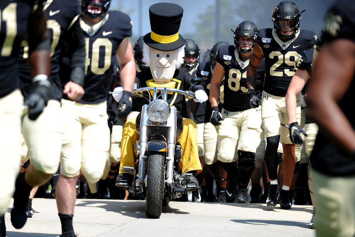Demon Deacon speeds through the player run-out on a motorcycle