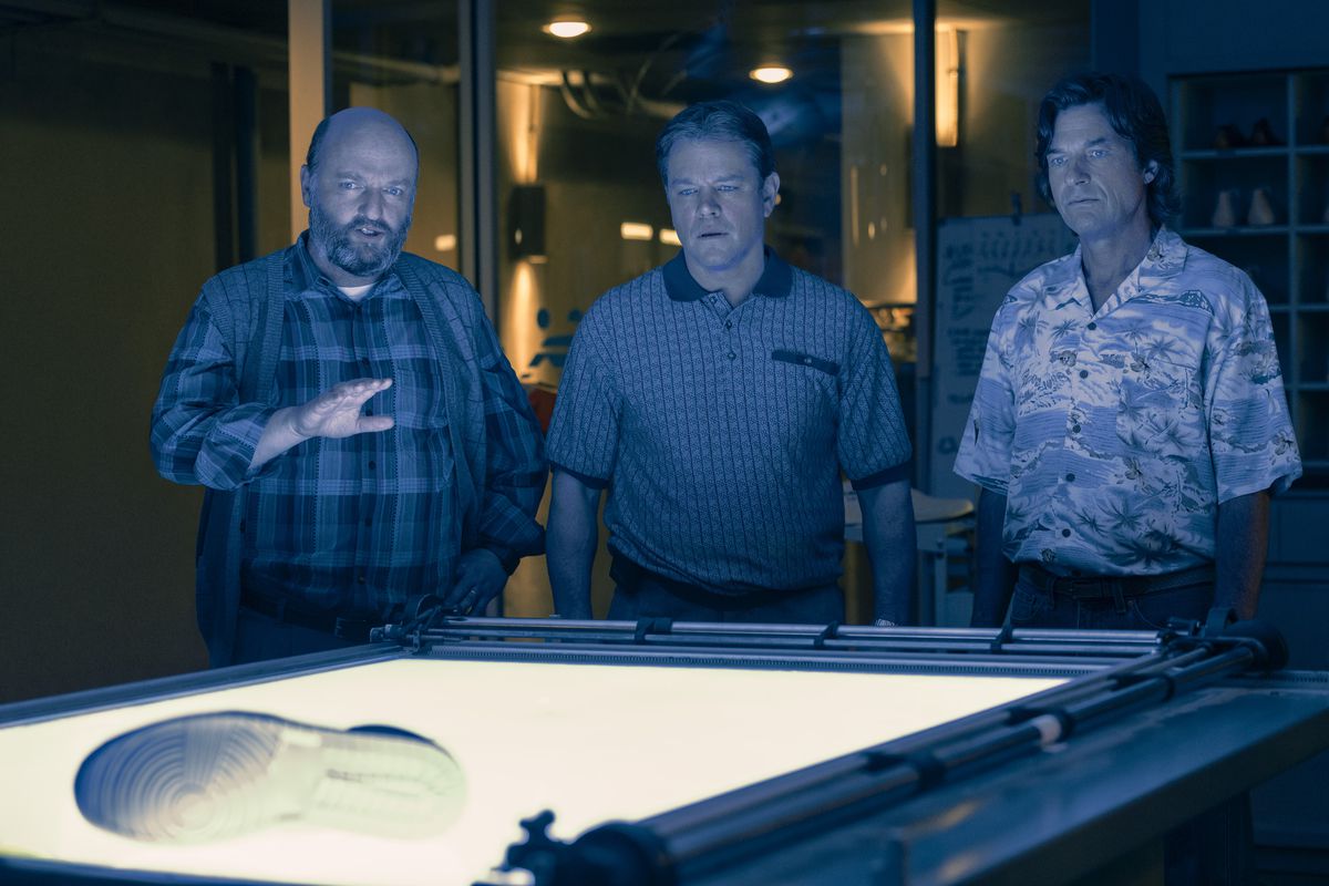 Three men, including Matt Damon and Jason Bateman, star at a shoe prototype in Nike’s lab in the film Air.