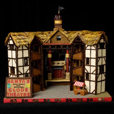 An amazing gingerbread house in the shape of Shakespeare’s globe theatre with a sign in front of it that says “Santa’s globe theatre.”