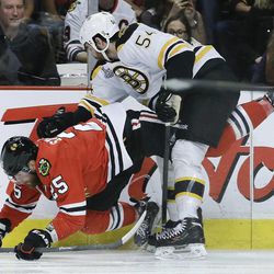 Chicago Blackhawks left wing Viktor Stalberg (25) loses his footing against Boston Bruins defenseman Adam McQuaid (54) in the second period during Game 5 of the NHL hockey Stanley Cup Finals, Saturday, June 22, 2013, in Chicago. (AP Photo/Nam Y. Huh)