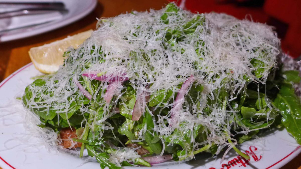 A giant heap of green salad with virtually no cutlet visible.