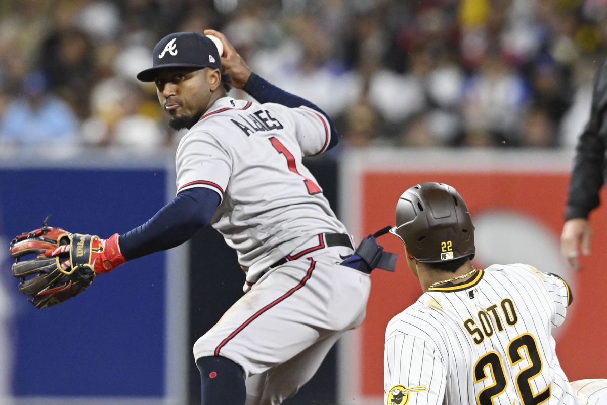 Ozzie Albies of the Atlanta Braves turns a double play at second base over Juan Soto #22 of the San Diego Padres to get Xander Bogaerts at first during the sixth inning April 18, 2023 at Petco Park in San Diego, California.