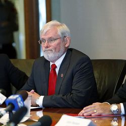 FILE - David Pershing, at center, president of the University of Utah, listens to questions as the U. releases findings from their swim team coach investigation in Salt Lake City, Tuesday, July 2, 2013. At left is Clark Ivory, chair of the board of trustees for the U. At right is Chris Hill, athletic director for the U.