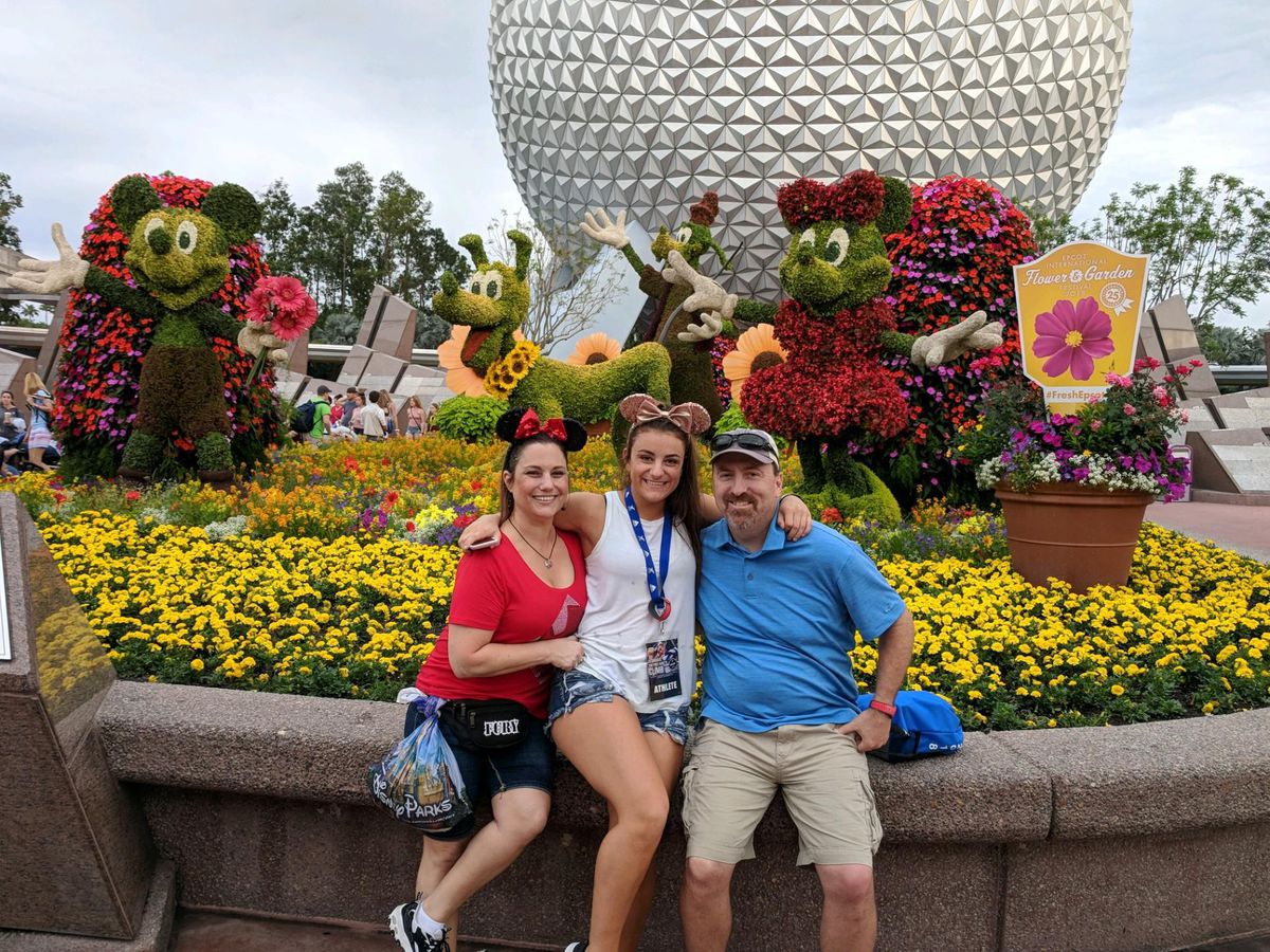 Eric and Rachelle Drage pose with their daughter at Epcot Theme Park in Orlando, Florida.