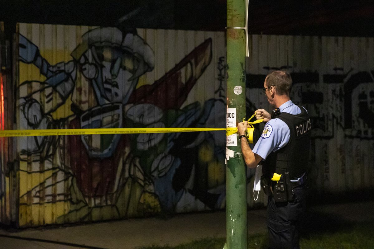 A Chicago police officer hangs crime scene tape early Sunday after a 14-year-old boy was shot in the 2500 block of South Trumbull in Little Village on the Southwest Side.