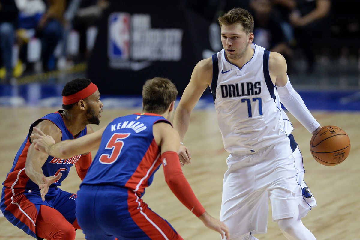 Dallas Mavericks forward Luka Doncic dribbles the ball while defended by Detroit Pistons guards Luke Kennard and Bruce Brown during the second half at Mexico City Arena.