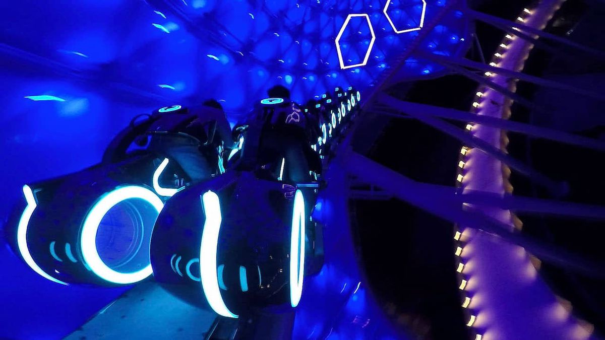 Riders travel on Tron lightcycles through a blue canopy in the Shanghai Disney version of TRON Lightcycle / Run 