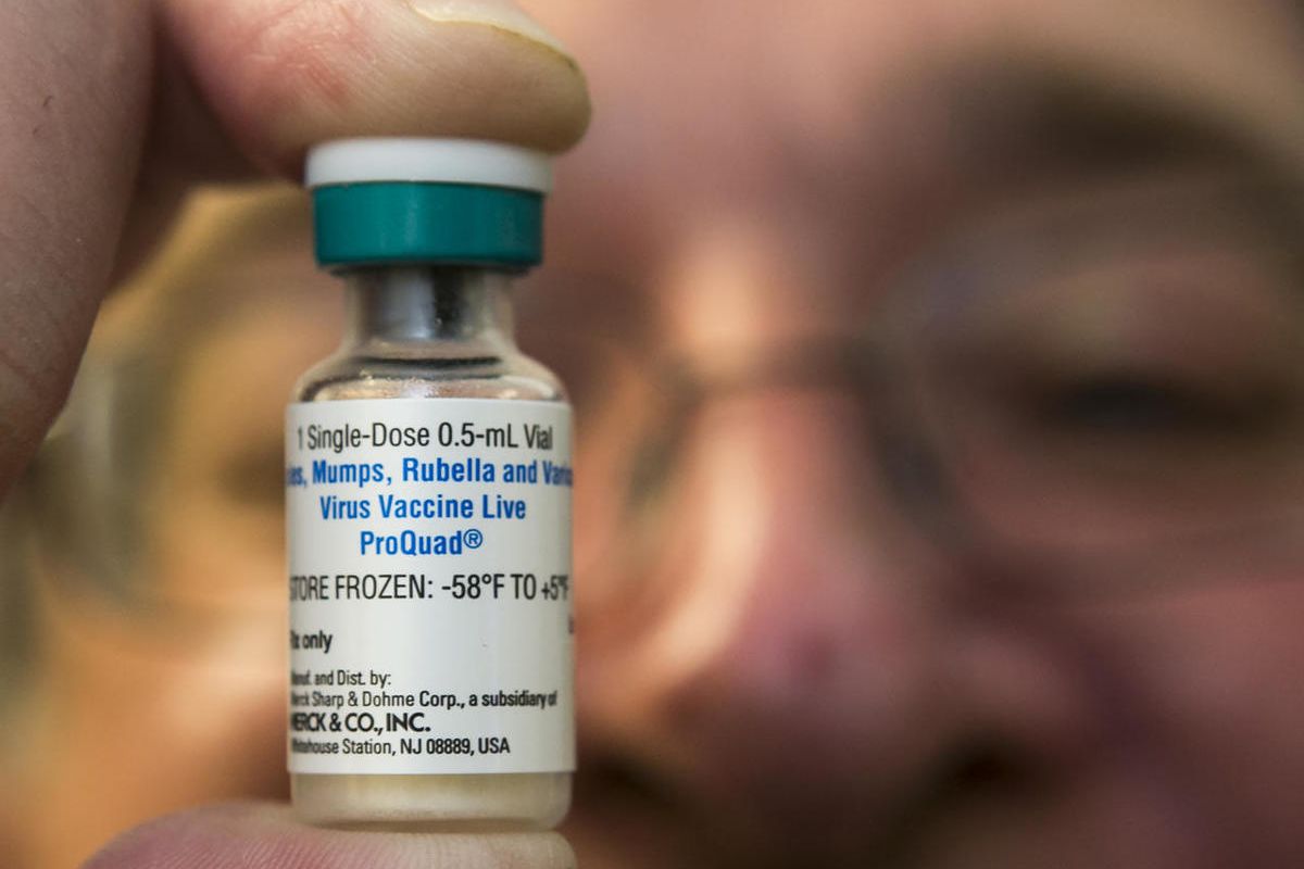 In this Thursday, Jan. 29, 2015 photo, a pediatrician holds a dose of the measles-mumps-rubella (MMR) vaccine at his practice in Northridge, Calif. Vaccinations can cause minor side effects including redness at the injection site and sometimes mild fever,