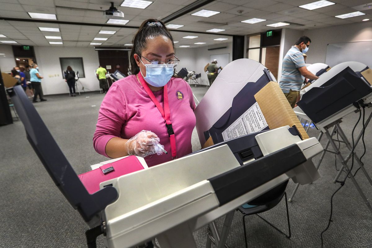 Elizabeth Winfrey, of Salt Lake City, joins other voters as she casts her ballot in person at the Salt Lake County Government Center during the first day of early voting in Utah on Tuesday, Oct. 20, 2020.
