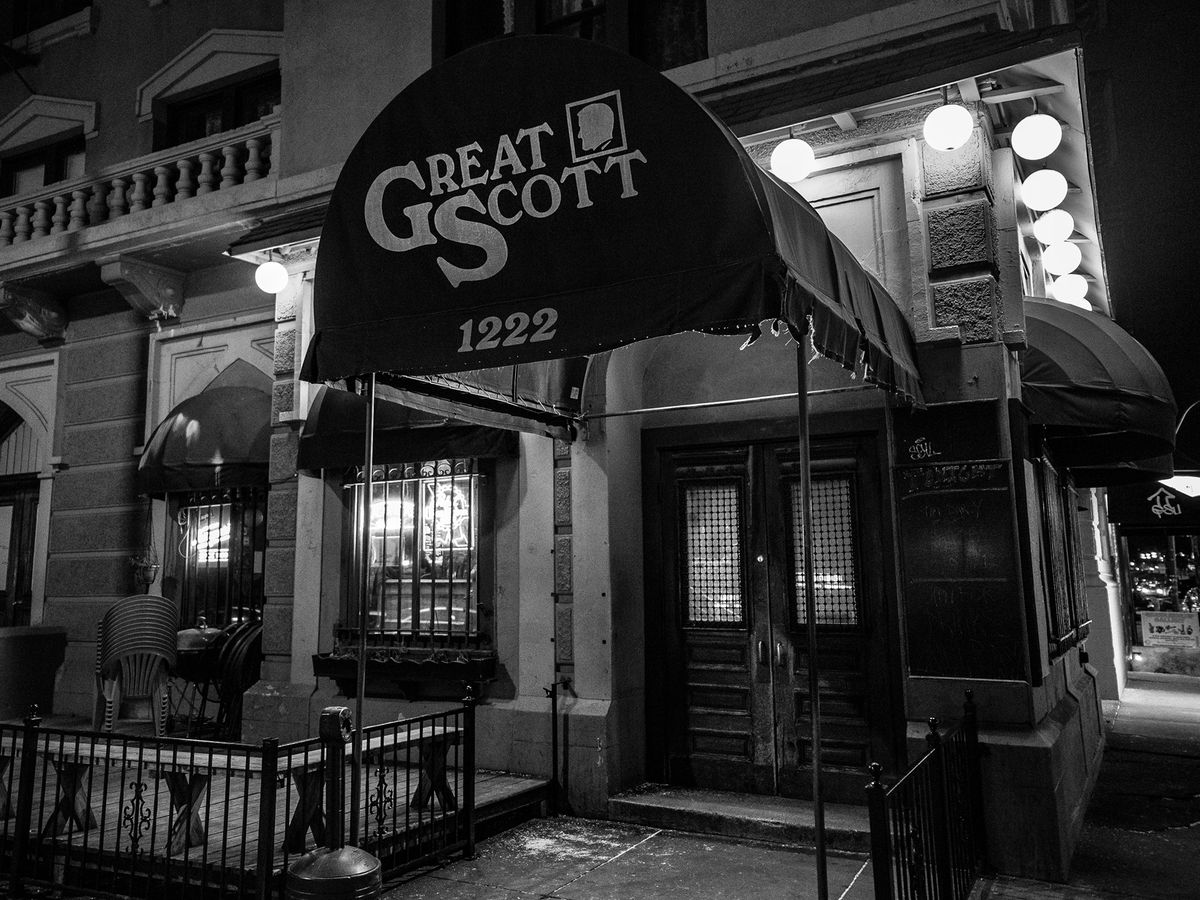 Exterior of a bar, with the name Great Scott written on the awning. The photo is black and white.