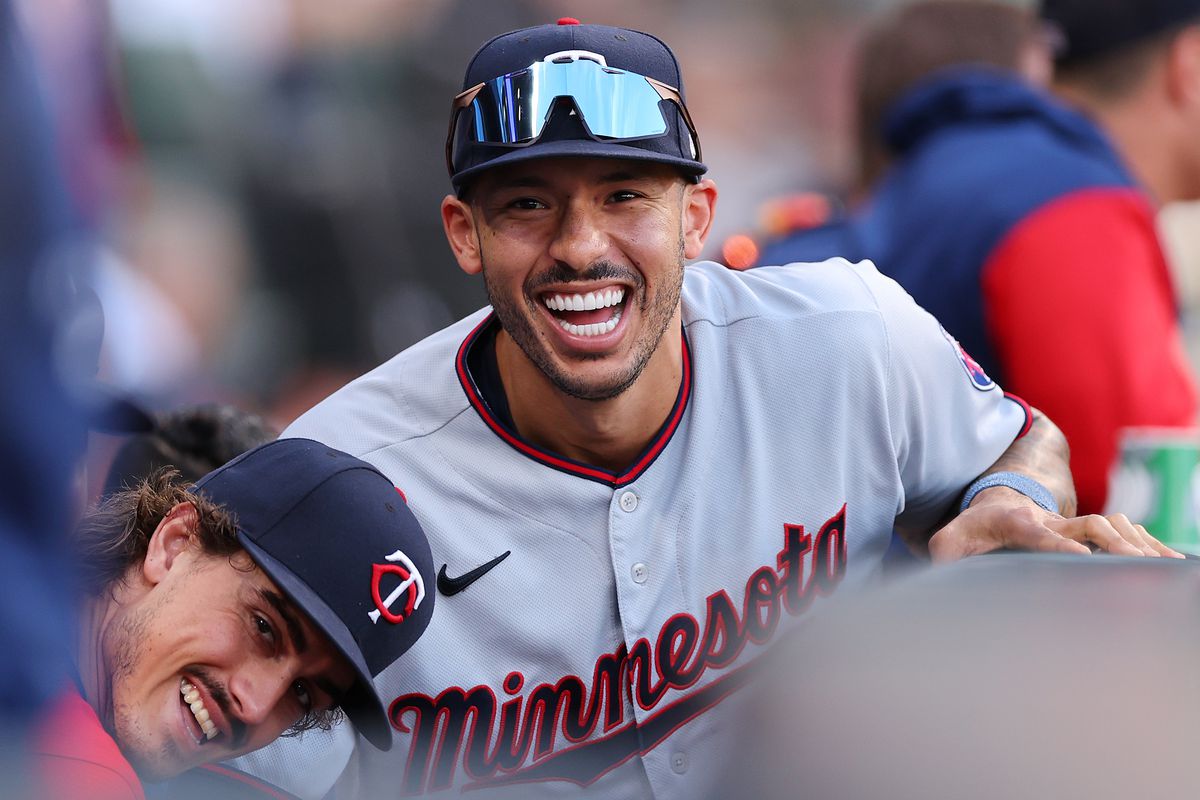 Carlos Correa laughing in the Twins dugout. 
