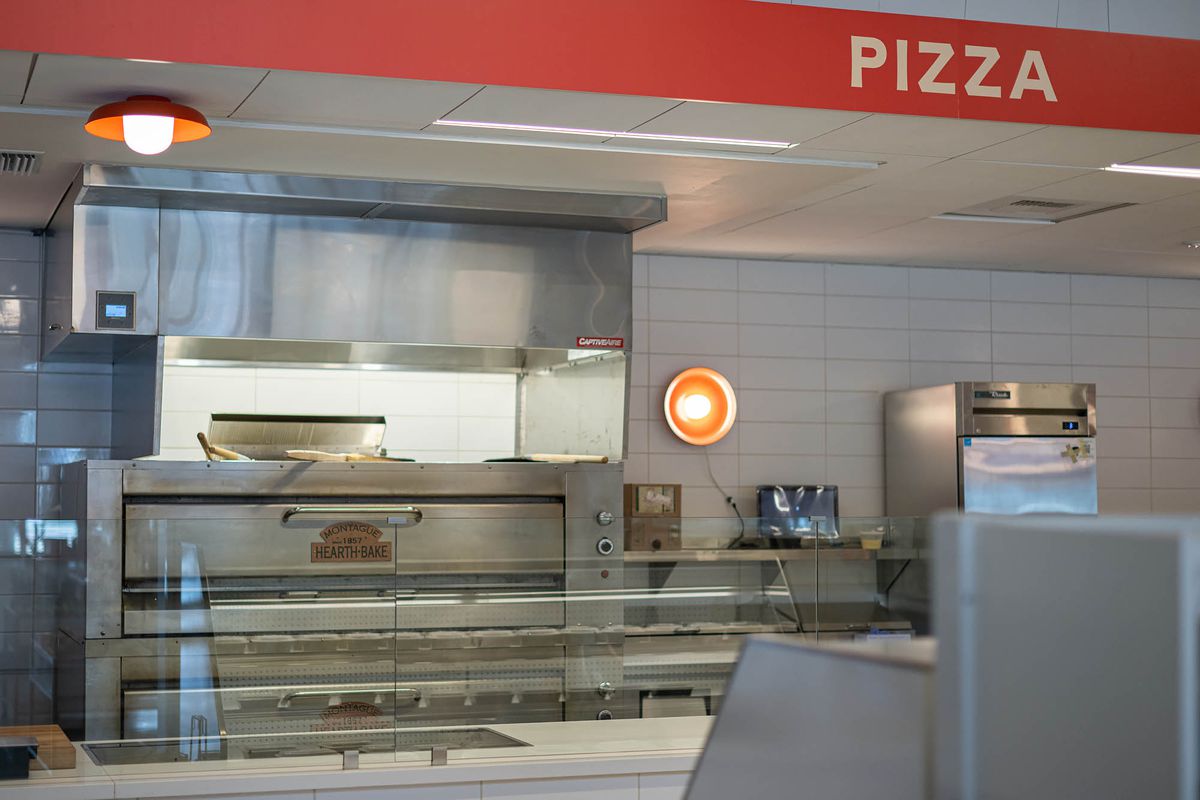 Metal pizza ovens ready to go at a takeaway marketplace.