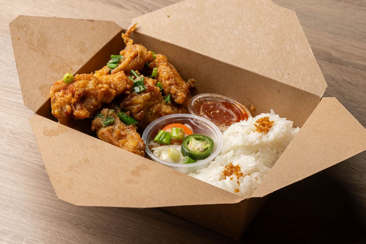 Wings and rice in a brown box.