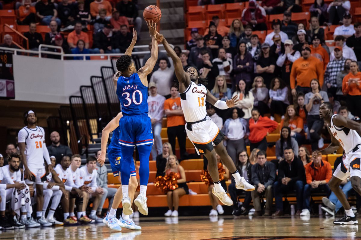 Kansas Jayhawks guard Ochai Agbaji (30) shoots a three point basket while defended by Oklahoma State Cowboys guard Isaac Likekele (13) during the first half at Gallagher-Iba Arena.