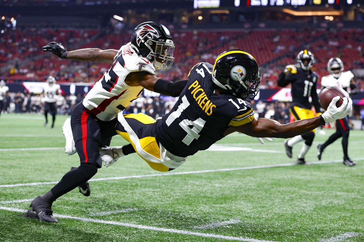 George Pickens #14 of the Pittsburgh Steelers leaps for a reception over Natrone Brooks #35 of the Atlanta Falcons during the first quarter of a preseason game at Mercedes-Benz Stadium on August 24, 2023 in Atlanta, Georgia.