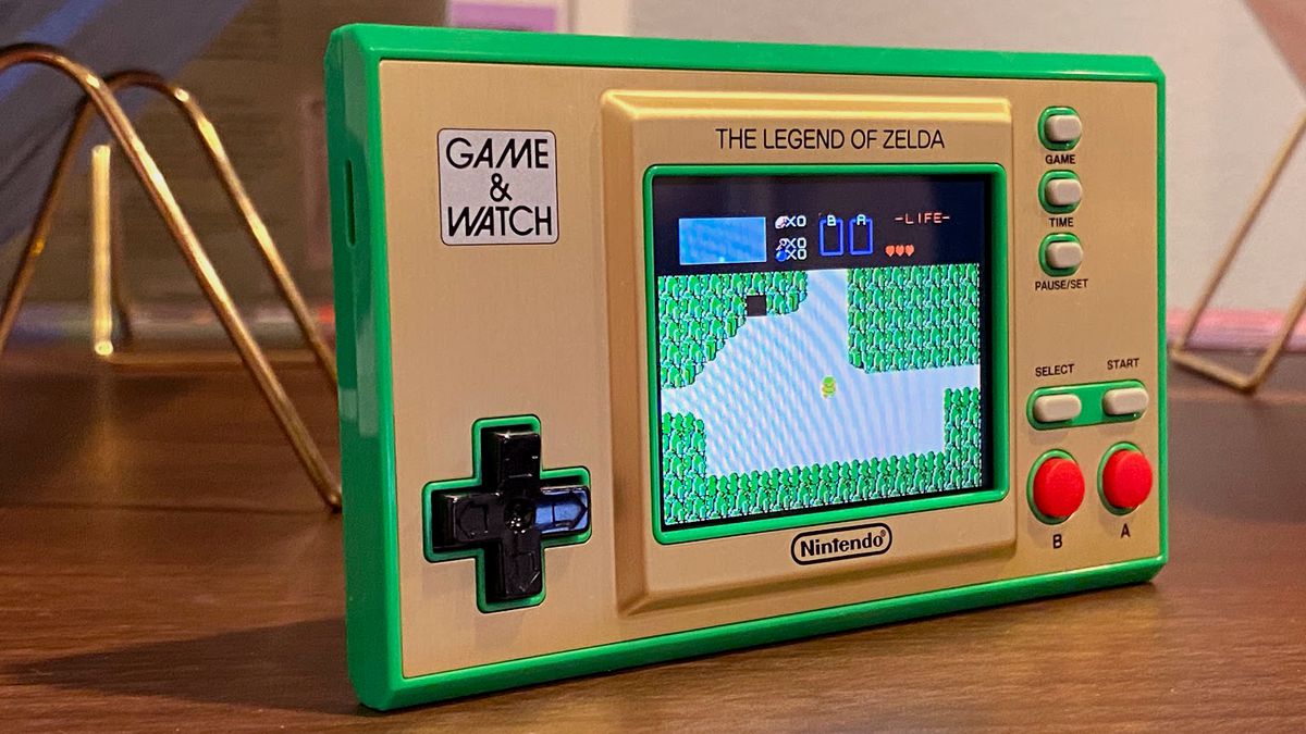 A Game &amp; Watch: The Legend of Zelda handheld sits on a wooden display case